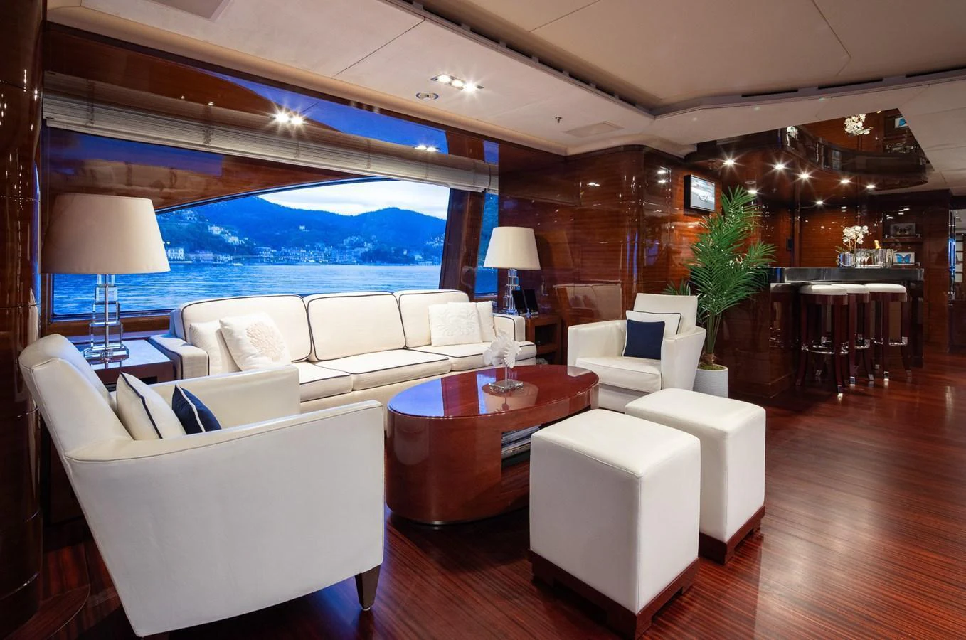The salon features luxurious seating with a stunning view through large windows. aboard VISION Yacht for Sale