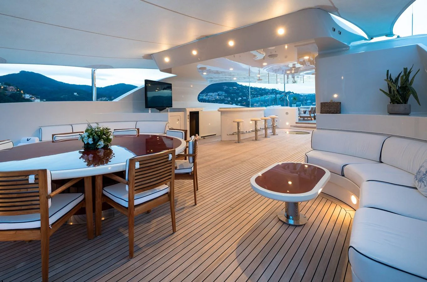The aft deck features a spacious seating area with a dining table and a bar, perfect for entertaining guests. aboard VISION Yacht for Sale