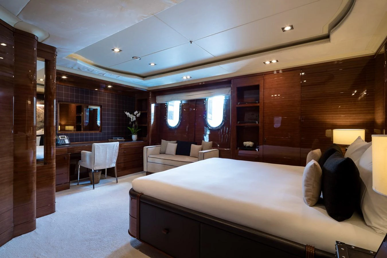 The master stateroom features elegant wood paneling, a plush bed, and ample natural light from the windows. aboard VISION Yacht for Sale