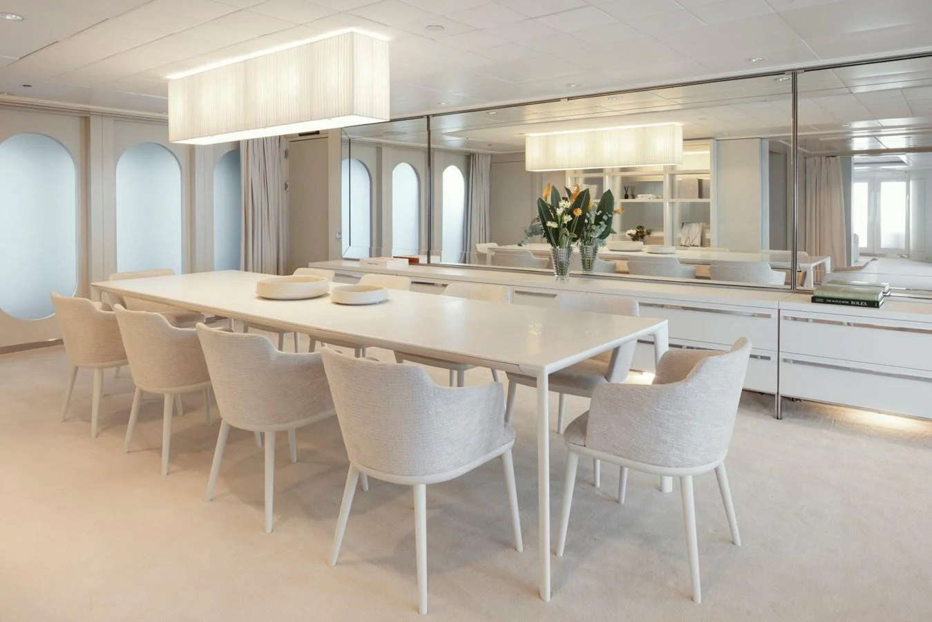 The yacht's dining area features a sleek, modern design with a long table and comfortable seating for eight. aboard IDOL Yacht for Sale