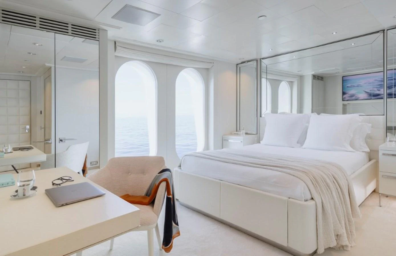 The stateroom features a luxurious bed with large windows offering a serene ocean view. aboard IDOL Yacht for Sale