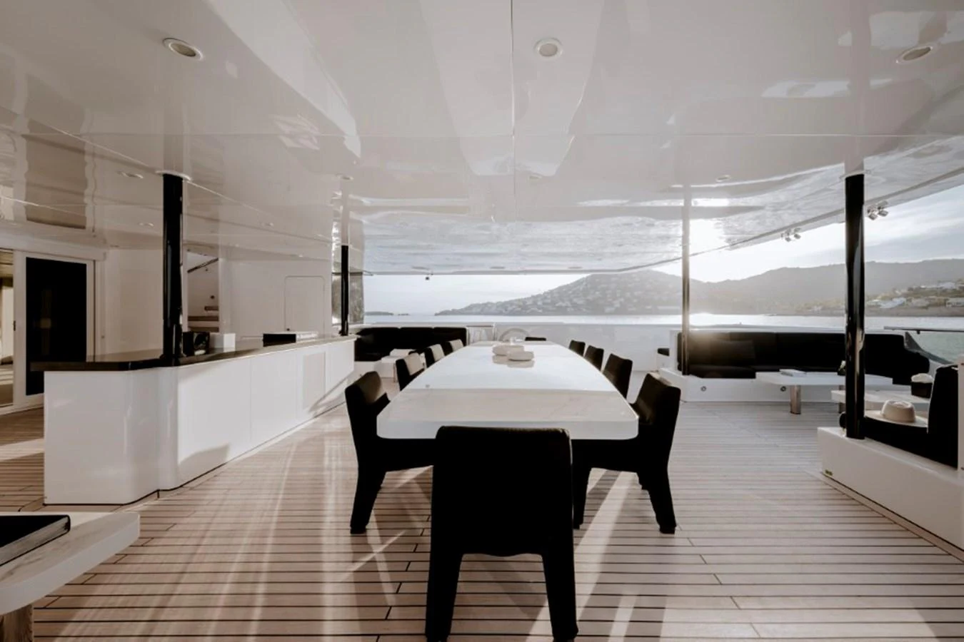 The aft deck features a spacious dining area with a sleek, modern design and stunning views. aboard IDOL Yacht for Sale