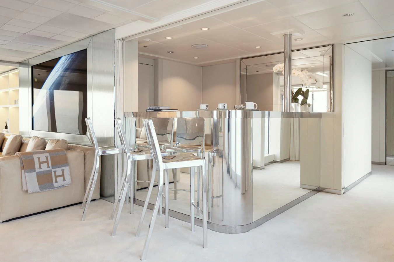 The salon features a sleek, modern design with a mirrored bar and comfortable seating. aboard IDOL Yacht for Sale