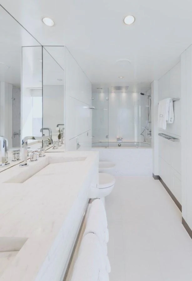 The yacht's bathroom features a sleek, modern design with white fixtures and ample lighting. aboard IDOL Yacht for Sale
