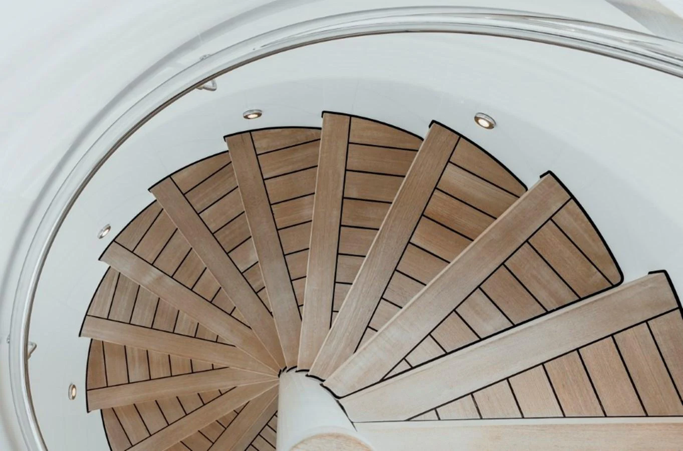 A beautifully crafted spiral staircase with wooden steps and elegant lighting. aboard IDOL Yacht for Sale