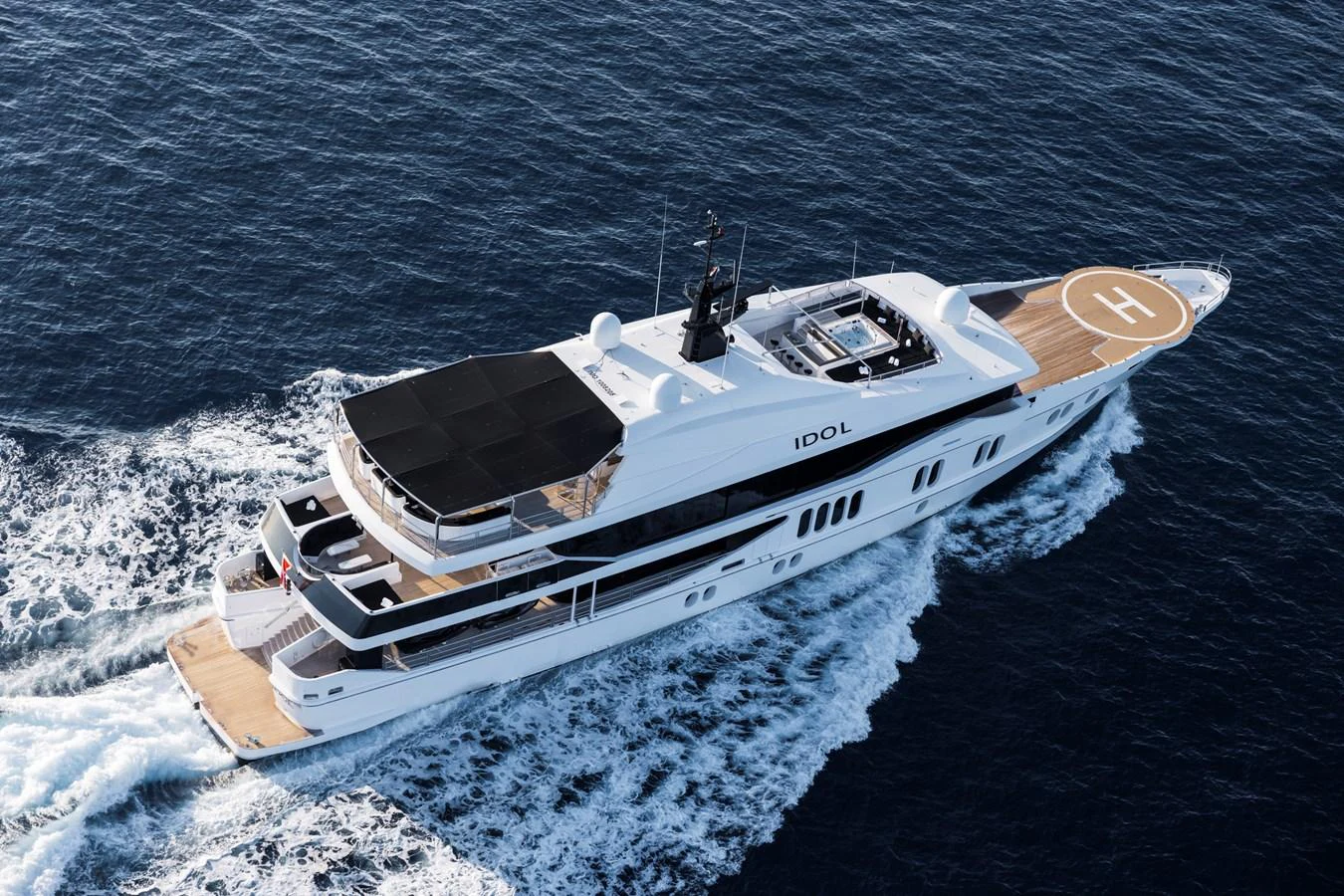 A sleek and modern yacht cruising through the open sea, showcasing its luxurious design and spacious deck areas. aboard IDOL Yacht for Sale