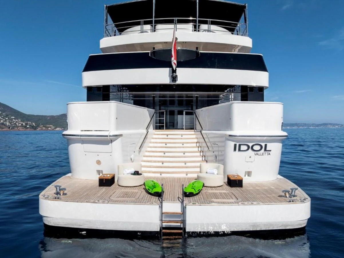 The yacht's stern features a spacious swim platform with steps leading up to the main deck, showcasing a luxurious and inviting design. aboard IDOL Yacht for Sale