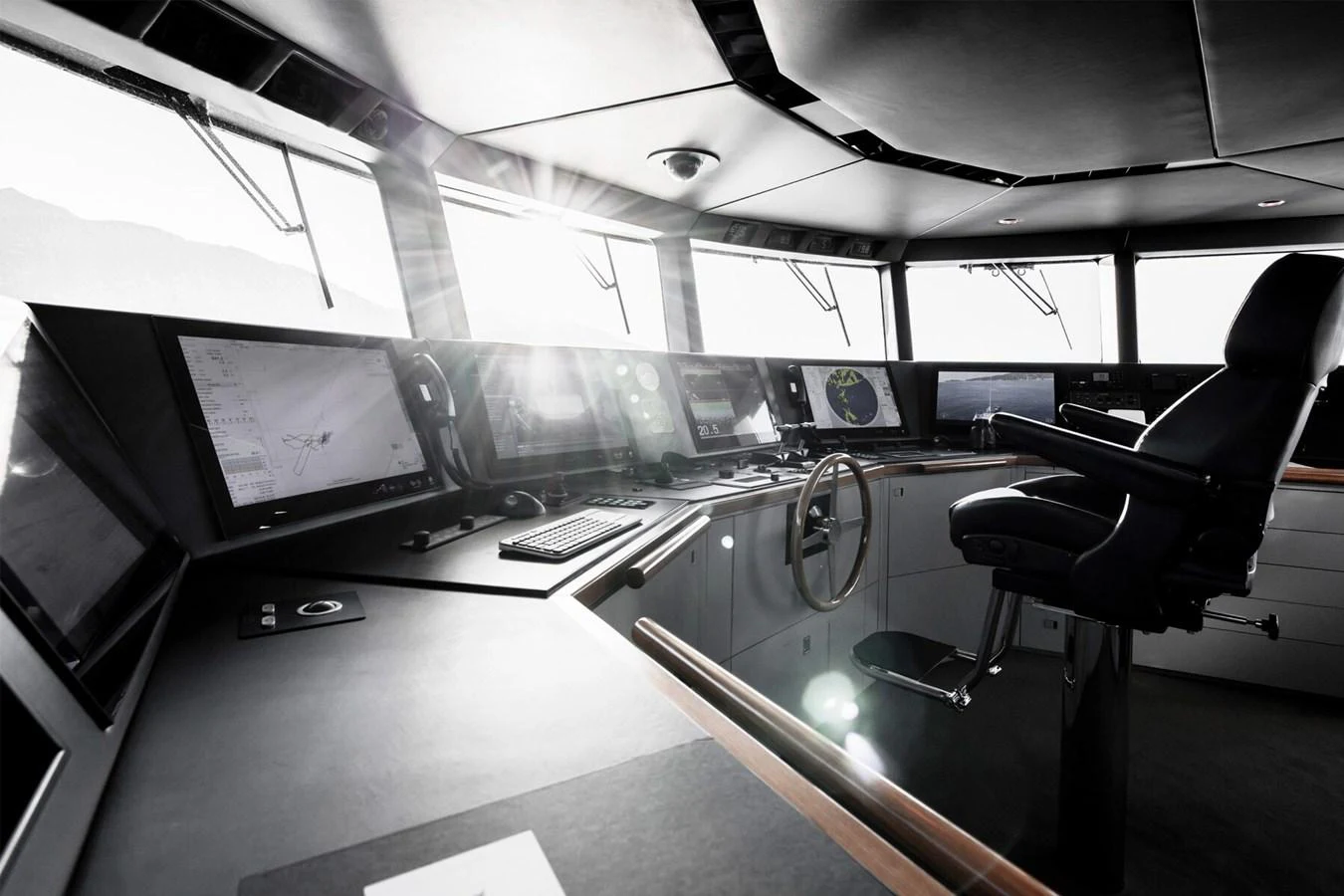 The helm station features advanced navigation equipment and a comfortable captain's chair, bathed in natural light. aboard RONIN Yacht for Sale