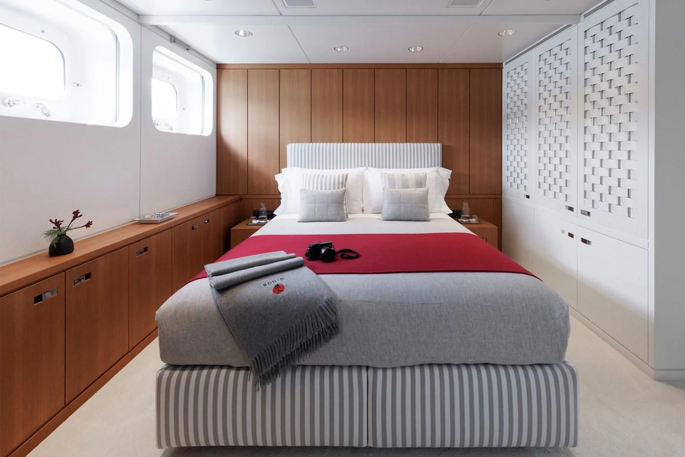 A luxurious stateroom featuring a comfortable bed with elegant linens and ample natural light. aboard RONIN Yacht for Sale