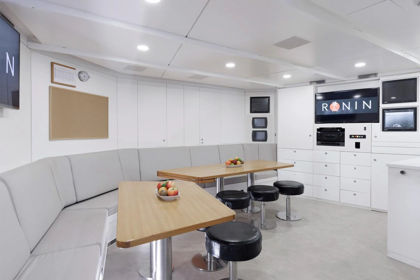 The crew mess area features comfortable seating, a dining table, and modern amenities for relaxation and dining. aboard RONIN Yacht for Sale