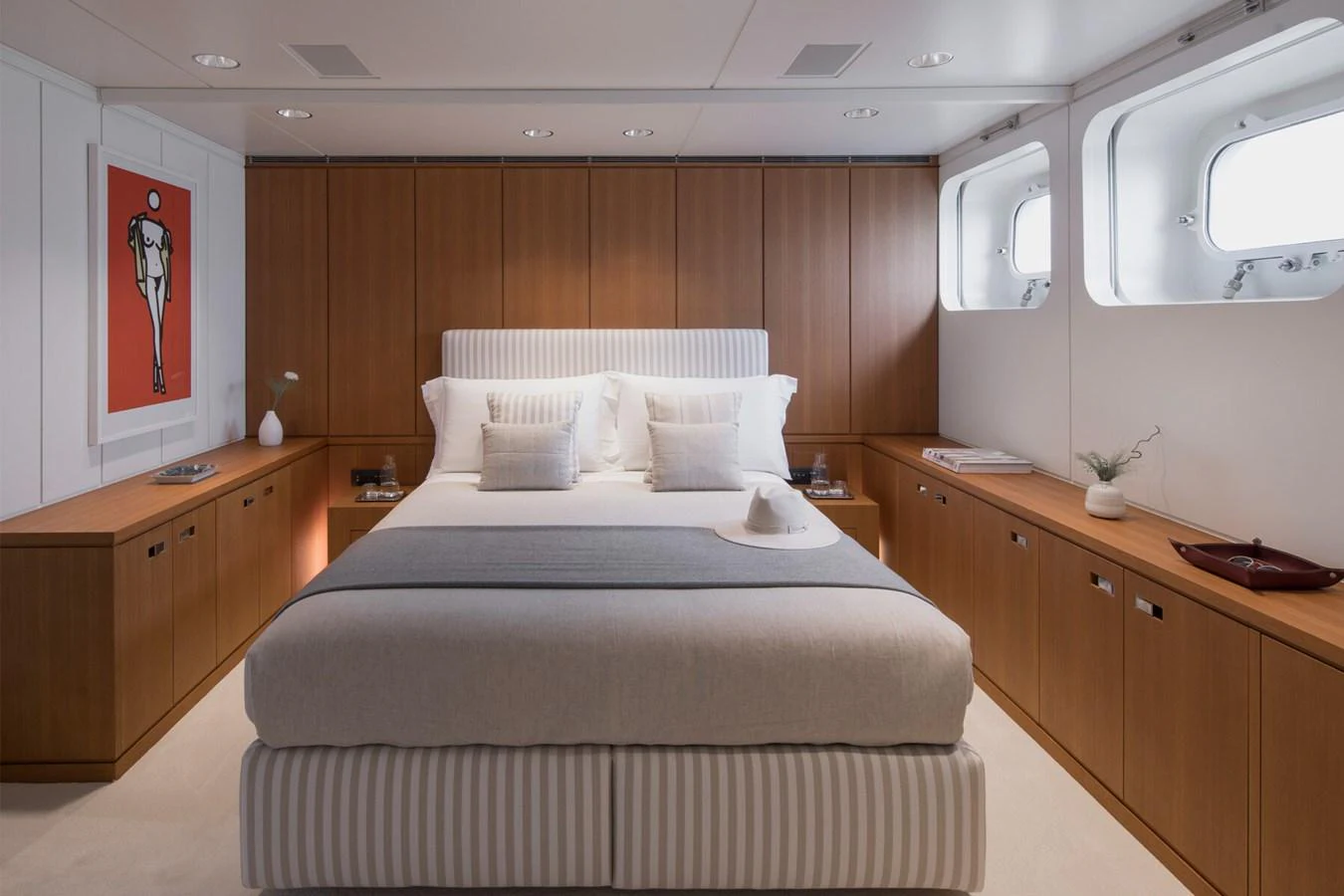 The master stateroom features a luxurious bed with elegant wood paneling and ample natural light from large windows. aboard RONIN Yacht for Sale