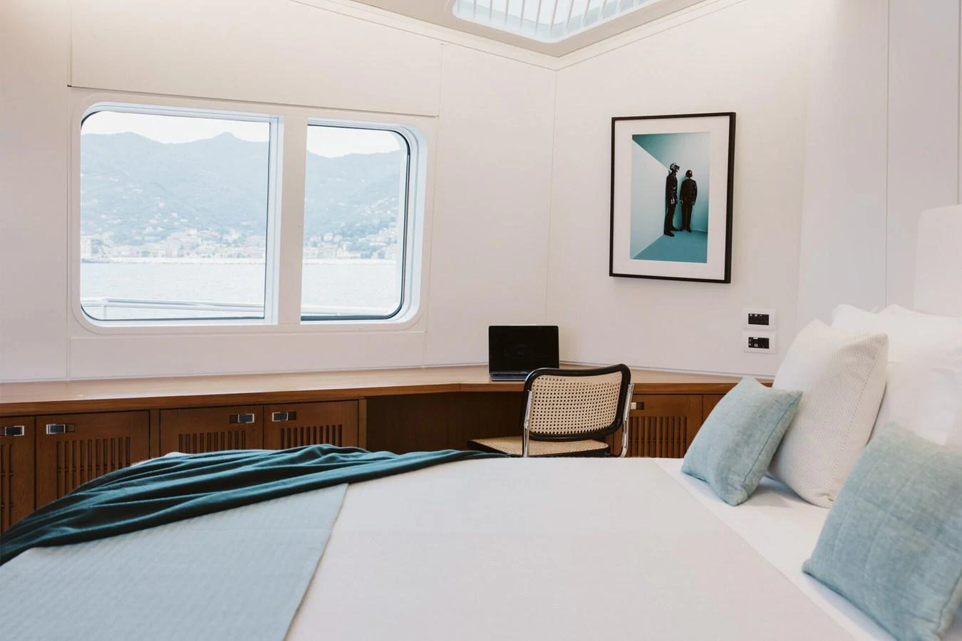 A serene stateroom featuring a large bed, a desk, and a picturesque view through the windows. aboard RONIN Yacht for Sale