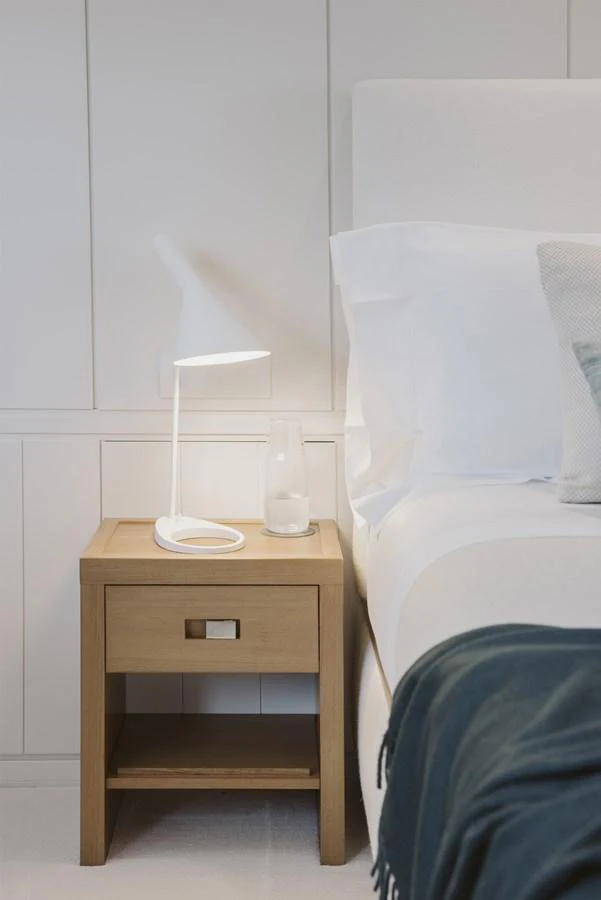 A serene stateroom with a cozy bedside setup, featuring a modern lamp and wooden nightstand. aboard RONIN Yacht for Sale
