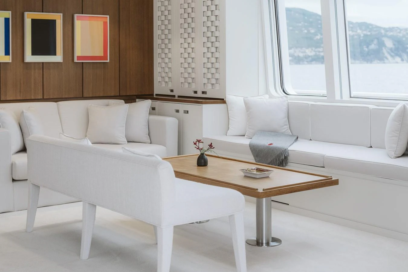 The yacht's interior features a stylish and comfortable seating area with large windows offering scenic views. aboard RONIN Yacht for Sale