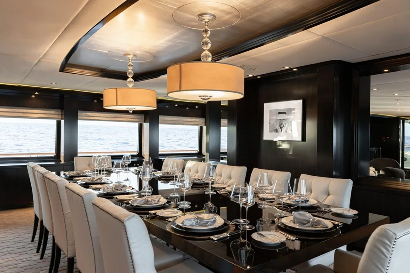 The yacht's dining area features an elegant table setting with plush seating and modern lighting. aboard CARPE DIEM Yacht for Sale