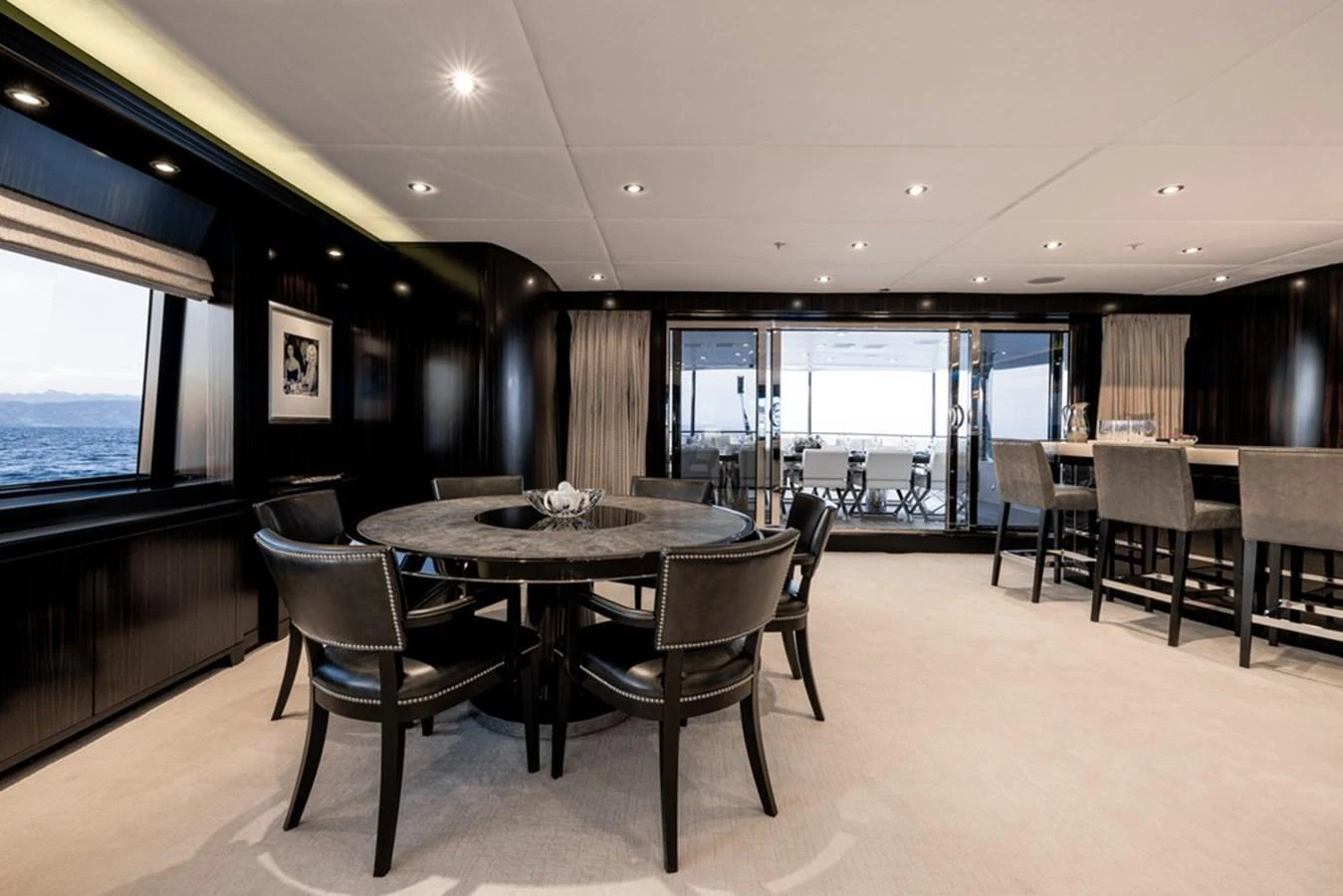 The yacht's dining area features elegant seating and a sophisticated ambiance with large windows offering stunning sea views. aboard CARPE DIEM Yacht for Sale