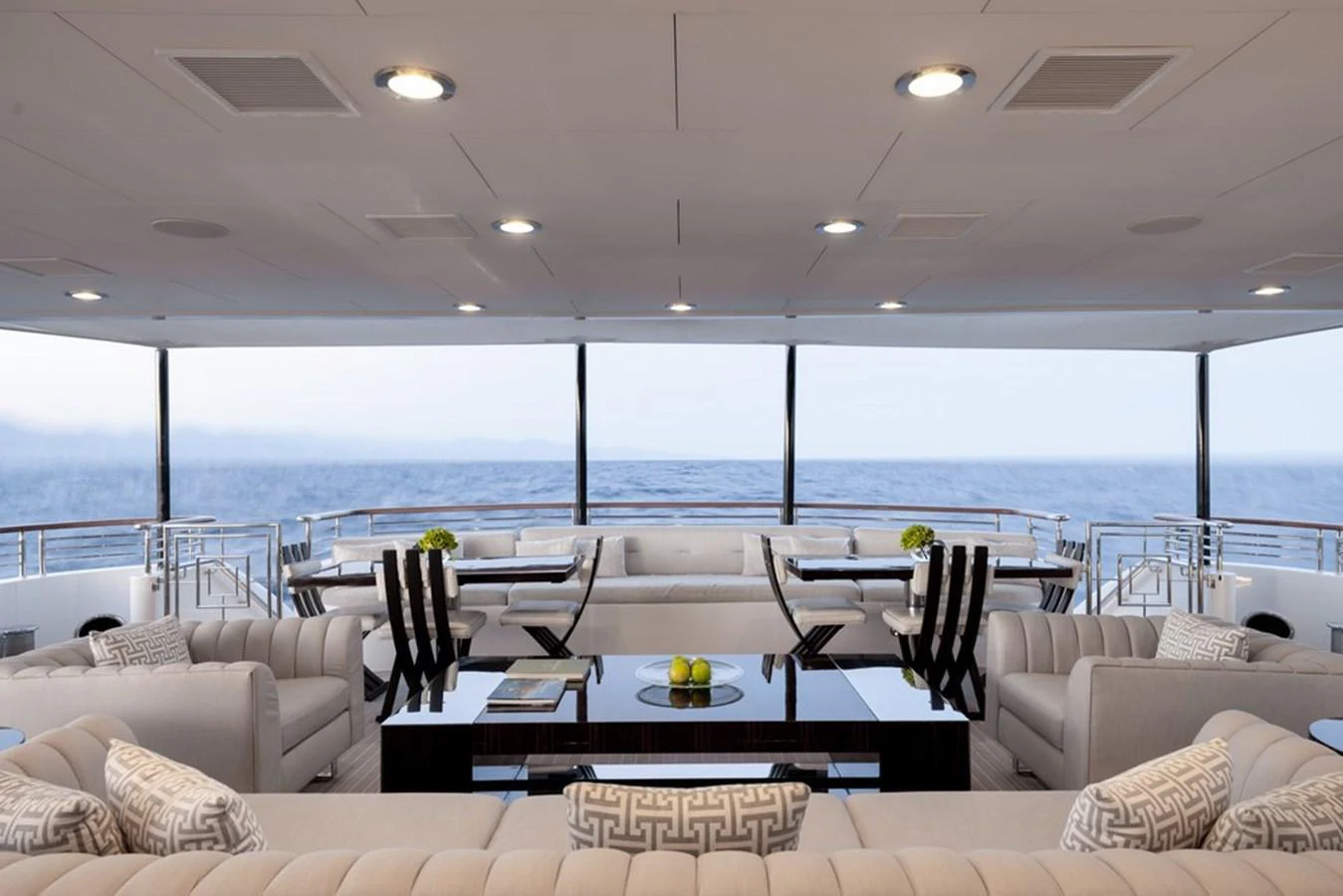The spacious salon offers panoramic ocean views with elegant seating and dining areas. aboard CARPE DIEM Yacht for Sale