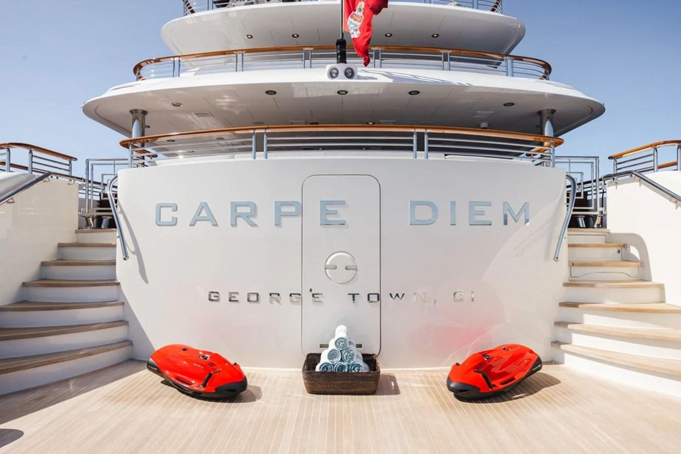 The aft deck of the yacht features elegant stairs and a welcoming layout with two red sea scooters. aboard CARPE DIEM Yacht for Sale