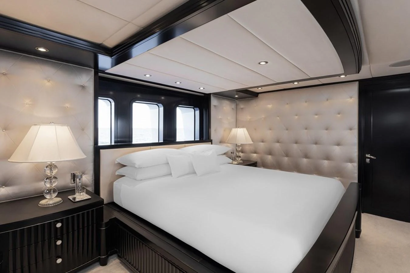The master stateroom features a luxurious bed with elegant lighting and plush decor. aboard CARPE DIEM Yacht for Sale