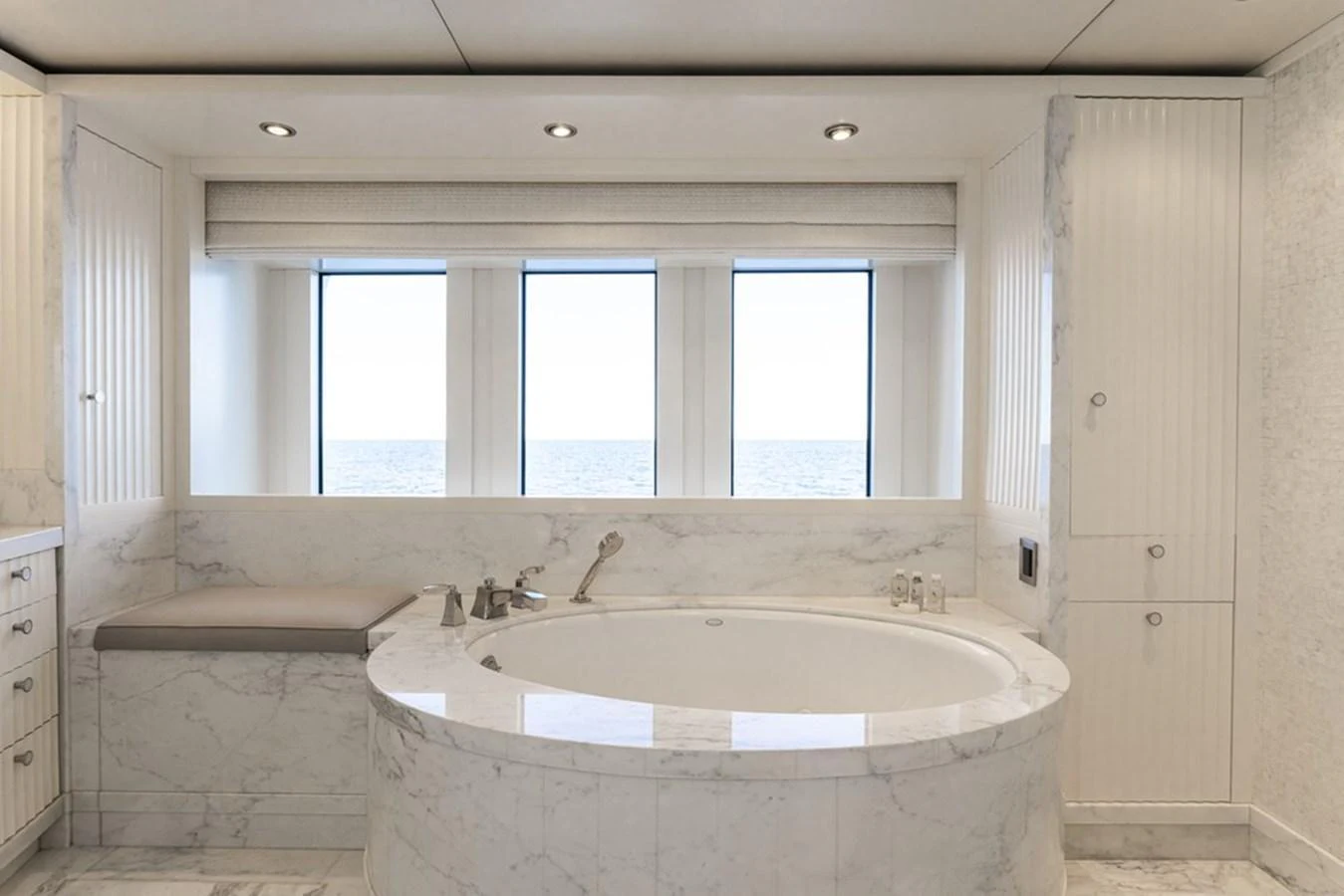 The luxurious bathroom features a large marble bathtub with a serene ocean view through the windows. aboard CARPE DIEM Yacht for Sale