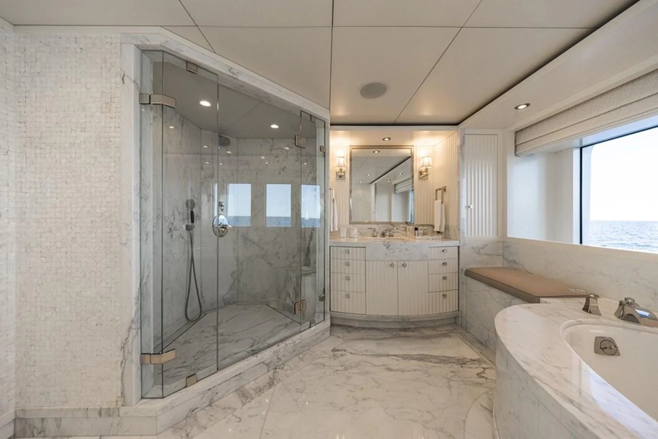 The luxurious bathroom features a spacious glass-enclosed shower and a large vanity with elegant marble finishes. aboard CARPE DIEM Yacht for Sale