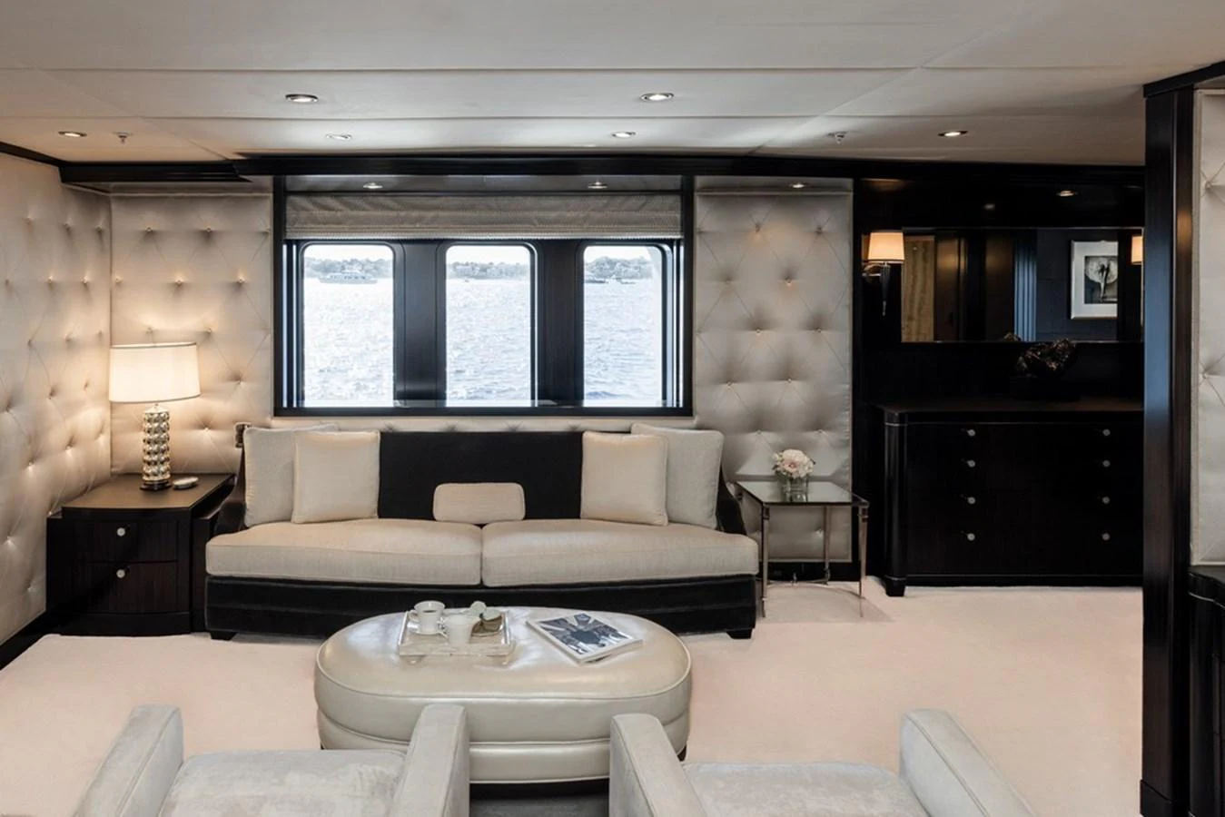 The yacht's interior features a luxurious seating area with plush furnishings and large windows offering a view of the water. aboard CARPE DIEM Yacht for Sale