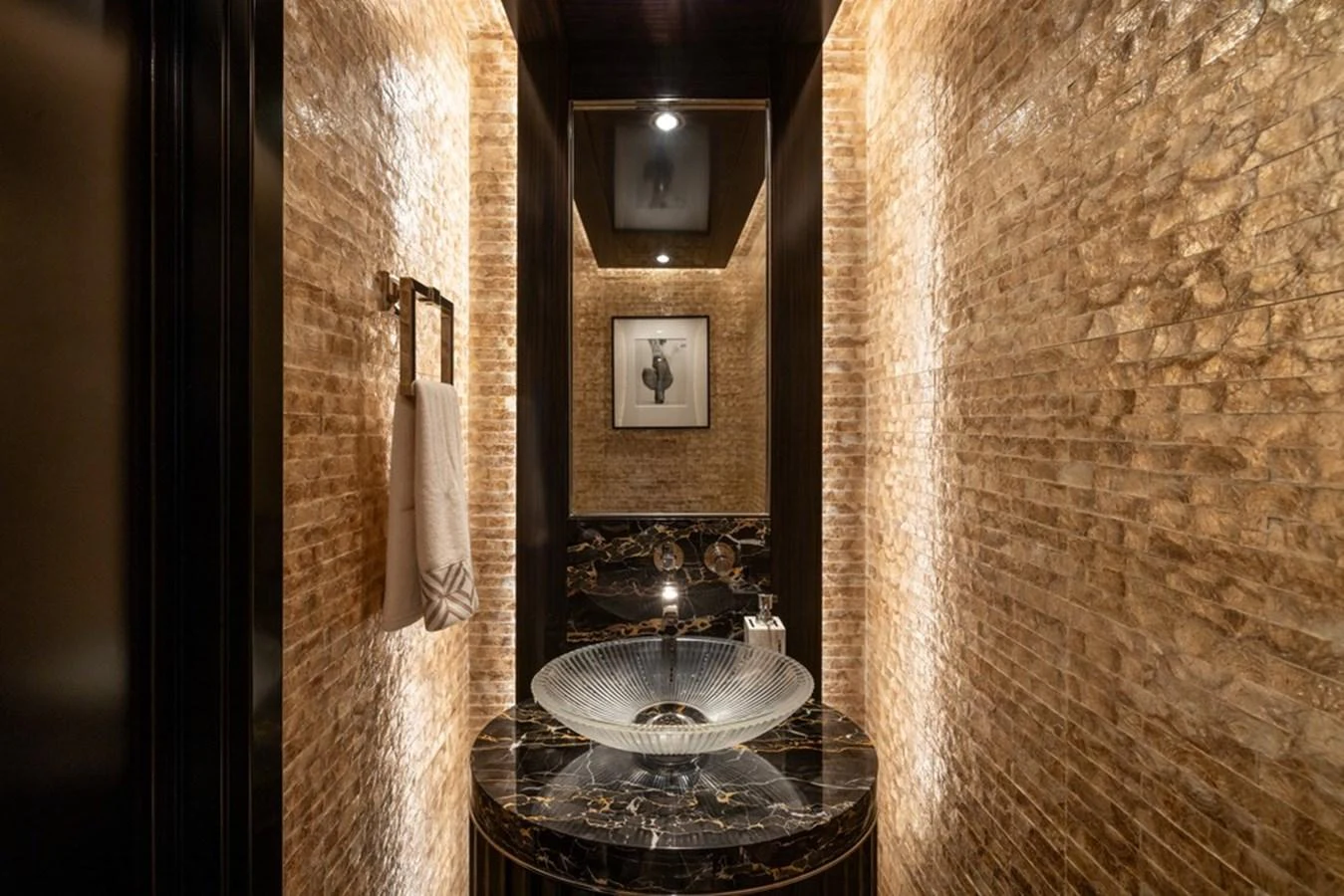 A luxurious bathroom with elegant lighting and a stylish glass sink. aboard CARPE DIEM Yacht for Sale