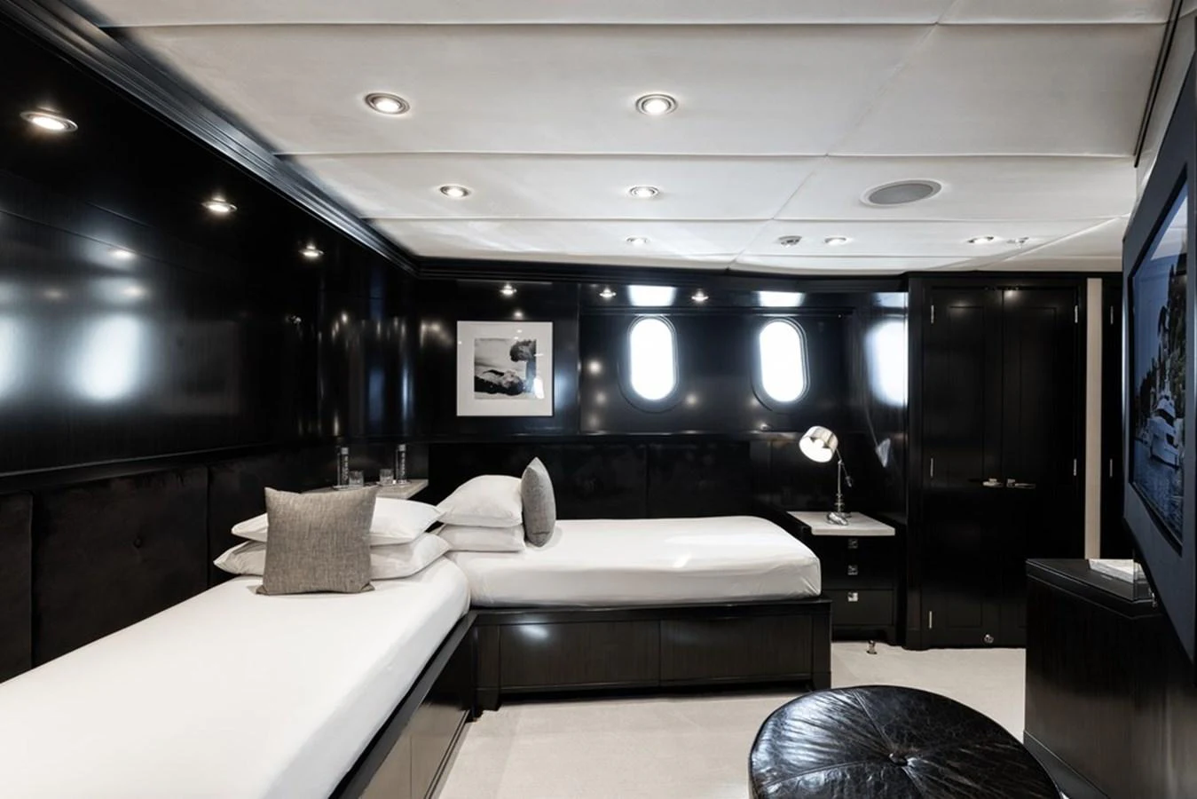 The guest stateroom features sleek black paneling and modern furnishings, creating a sophisticated and comfortable retreat. aboard CARPE DIEM Yacht for Sale