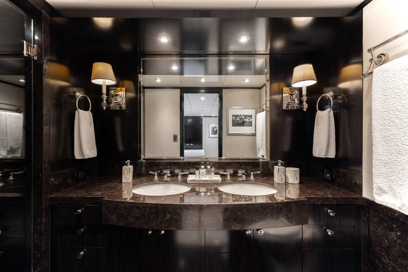 The luxurious bathroom features a double sink vanity with elegant fixtures and ambient lighting. aboard CARPE DIEM Yacht for Sale