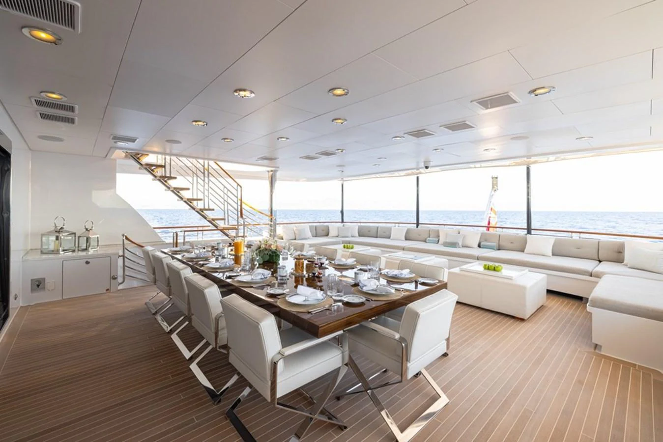 The aft deck features an elegant dining area with a large table and comfortable seating, perfect for alfresco meals with a view of the sea. aboard CARPE DIEM Yacht for Sale