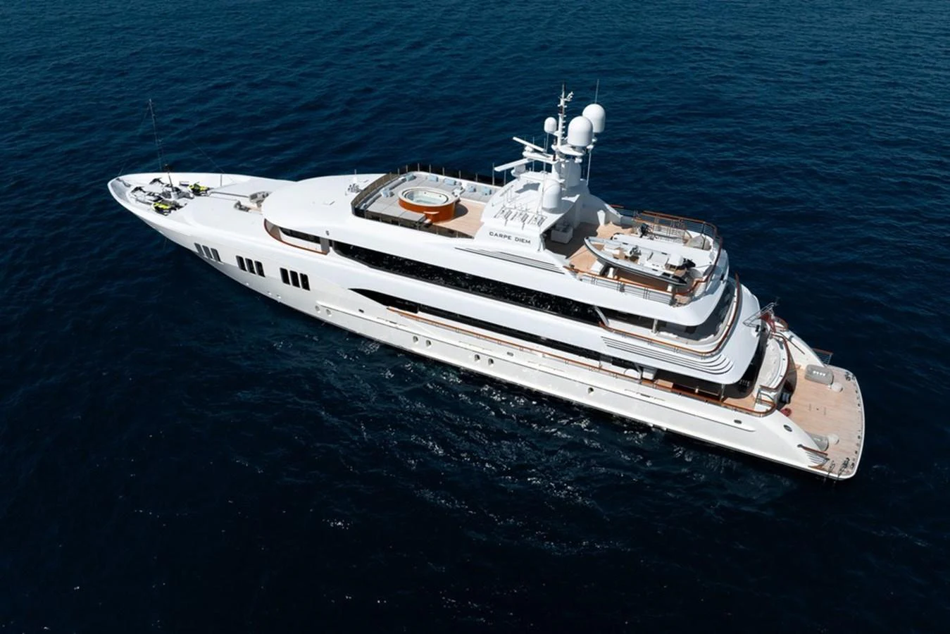 A stunning white yacht glides gracefully over the deep blue sea, showcasing its sleek design and luxurious amenities. aboard CARPE DIEM Yacht for Sale