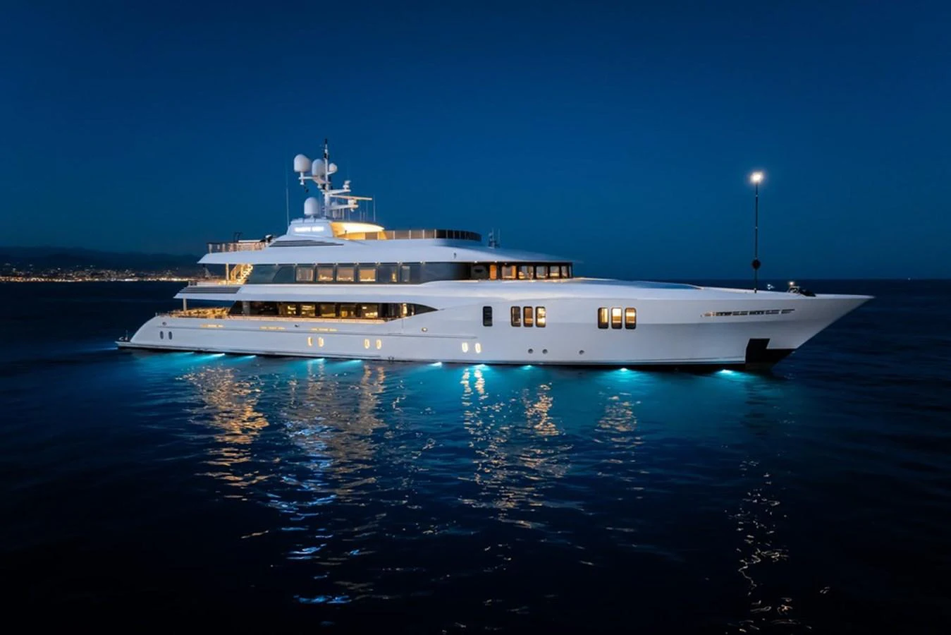 A luxurious yacht illuminated against the night sky, showcasing its elegant design and grandeur. aboard CARPE DIEM Yacht for Sale