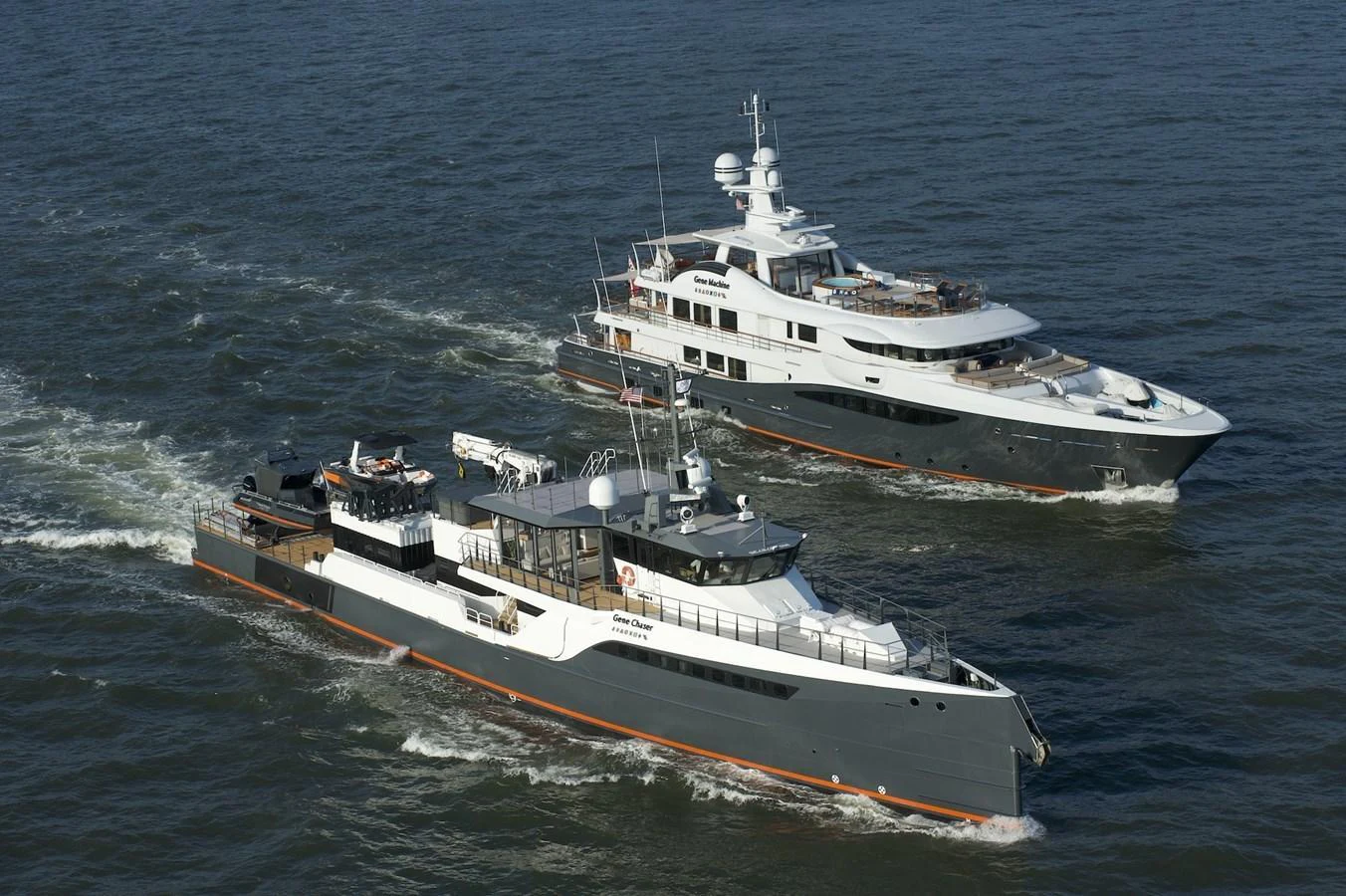 Two yachts cruise side by side on open water, showcasing their sleek designs and luxurious features. aboard GENE CHASER Yacht for Sale