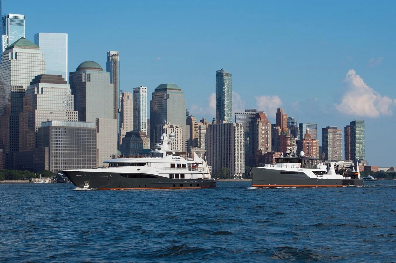 Two yachts cruise along a city skyline, showcasing their sleek designs against an urban backdrop. aboard GENE CHASER Yacht for Sale