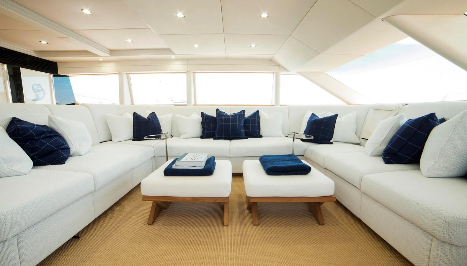 The spacious salon features plush white seating with navy accents, creating a comfortable and elegant atmosphere. aboard OCEANA I Yacht for Sale