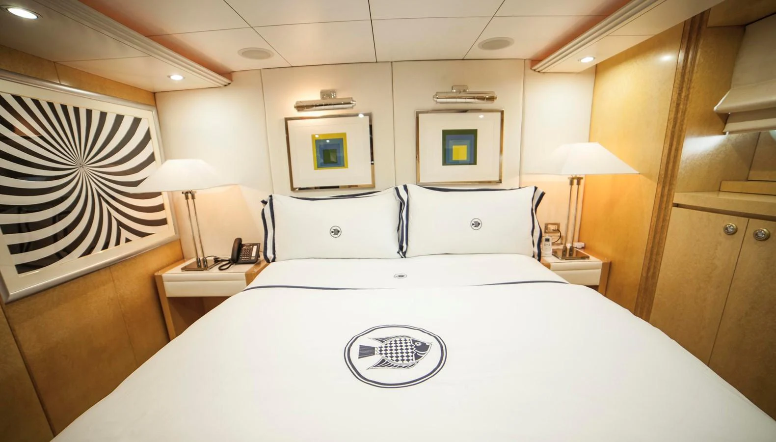 A cozy stateroom featuring a comfortable bed with elegant linens and modern artwork. aboard OCEANA I Yacht for Sale