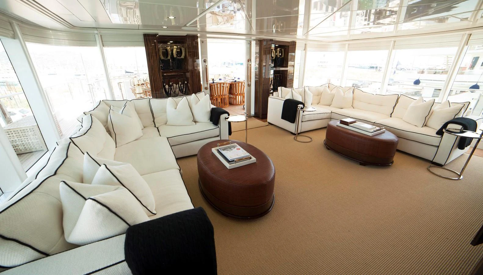 The salon features plush white seating with elegant dark accents, creating a luxurious and inviting atmosphere. aboard OCEANA I Yacht for Sale