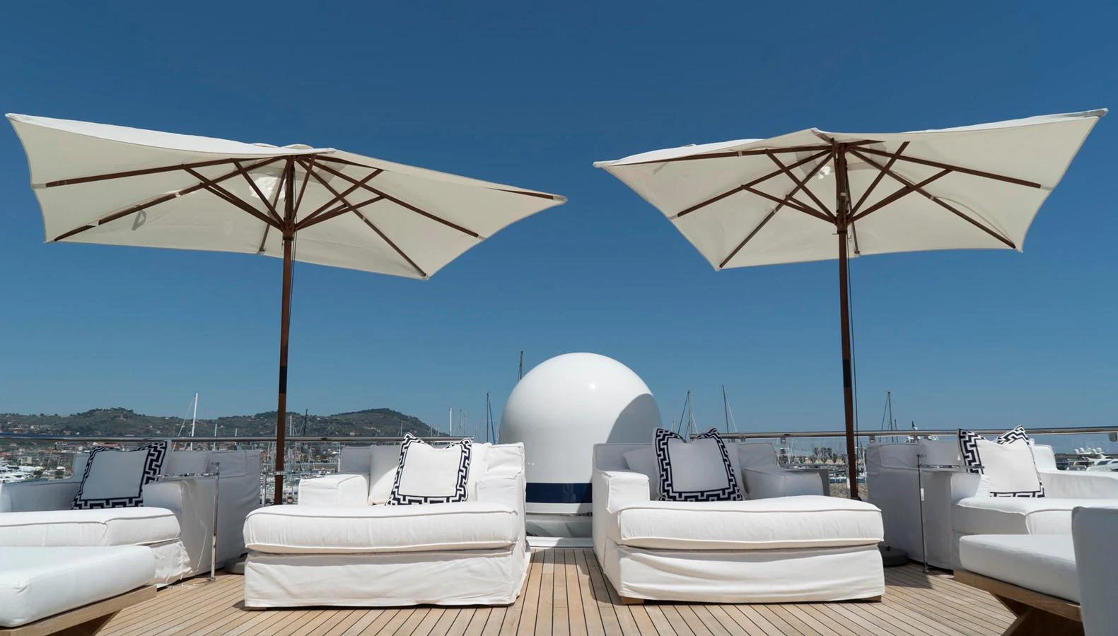 The sundeck offers luxurious lounging with plush white seating and large umbrellas for shade. aboard OCEANA I Yacht for Sale