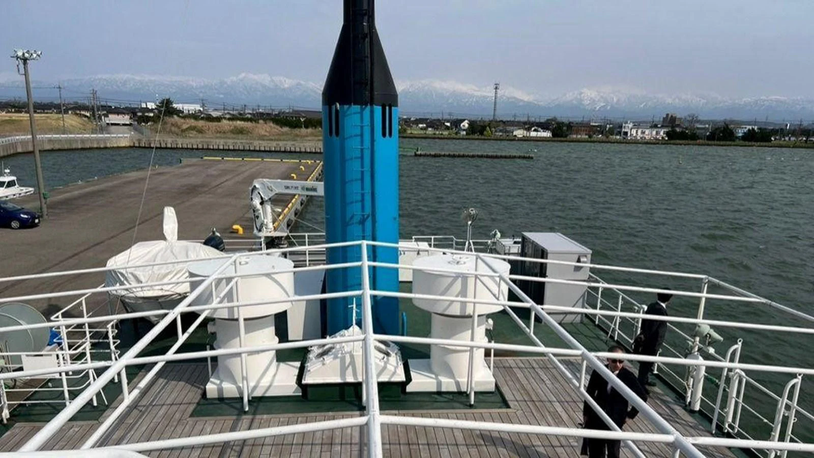 The yacht's deck features a spacious layout with a prominent blue and black structure at the center. aboard CUSTOM Yacht for Sale