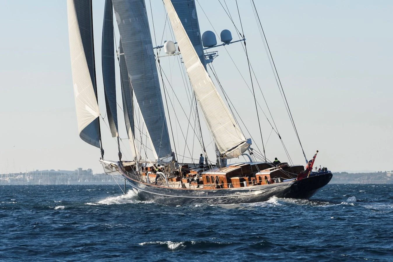 A majestic sailing yacht glides gracefully on the open sea with its sails fully extended. aboard METEOR Yacht for Sale
