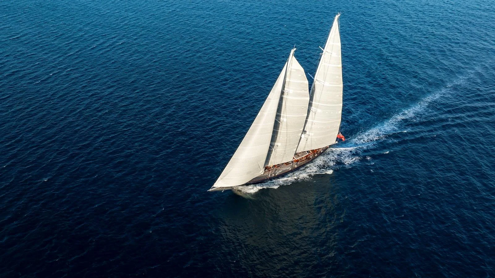 A stunning sailing yacht glides gracefully across the deep blue sea. aboard METEOR Yacht for Sale