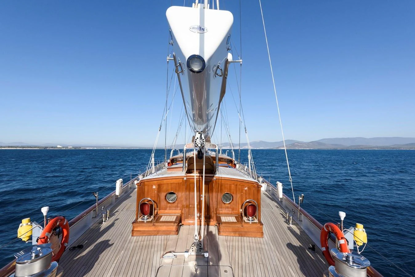 A stunning view of the yacht's deck with polished wood and clear blue waters in the background. aboard METEOR Yacht for Sale