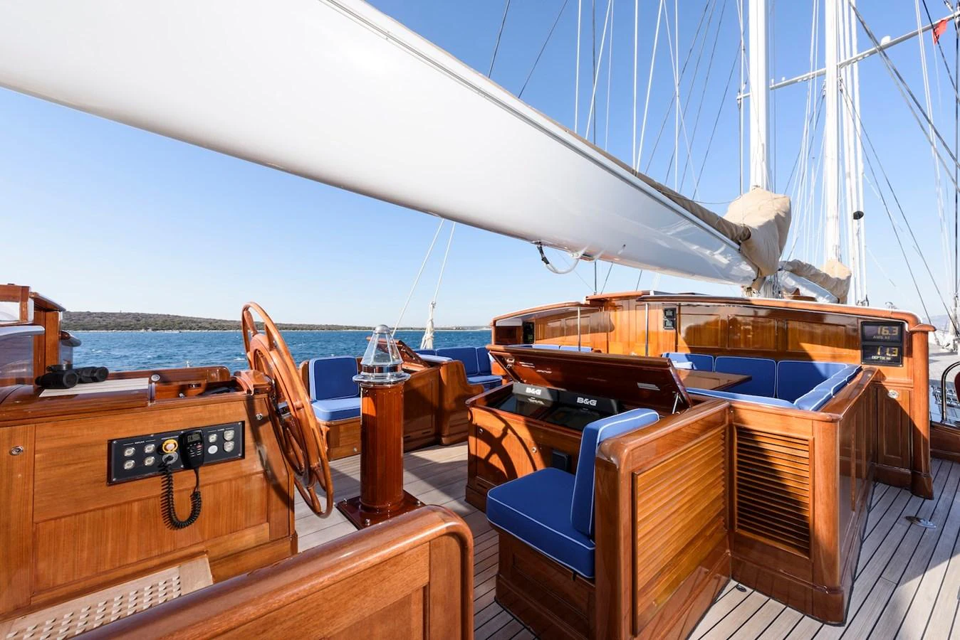 The yacht's cockpit features elegant wooden finishes and comfortable blue seating, offering a perfect space for relaxation and navigation. aboard METEOR Yacht for Sale