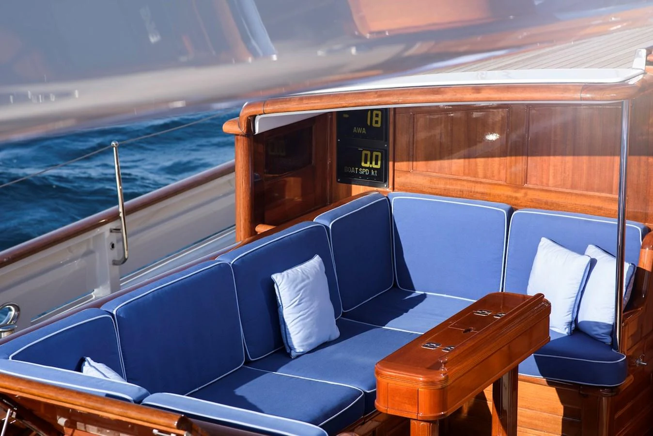 The aft deck features a comfortable seating area with blue cushions and wooden accents, perfect for relaxation. aboard METEOR Yacht for Sale