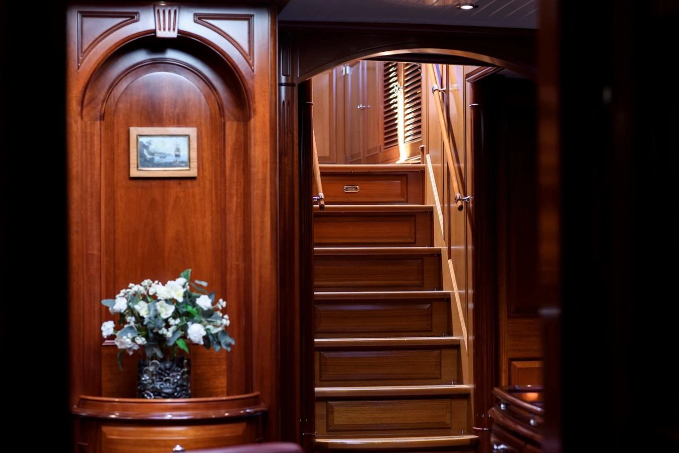 A luxurious interior hallway with wooden finishes and a staircase leading to the upper deck. aboard METEOR Yacht for Sale