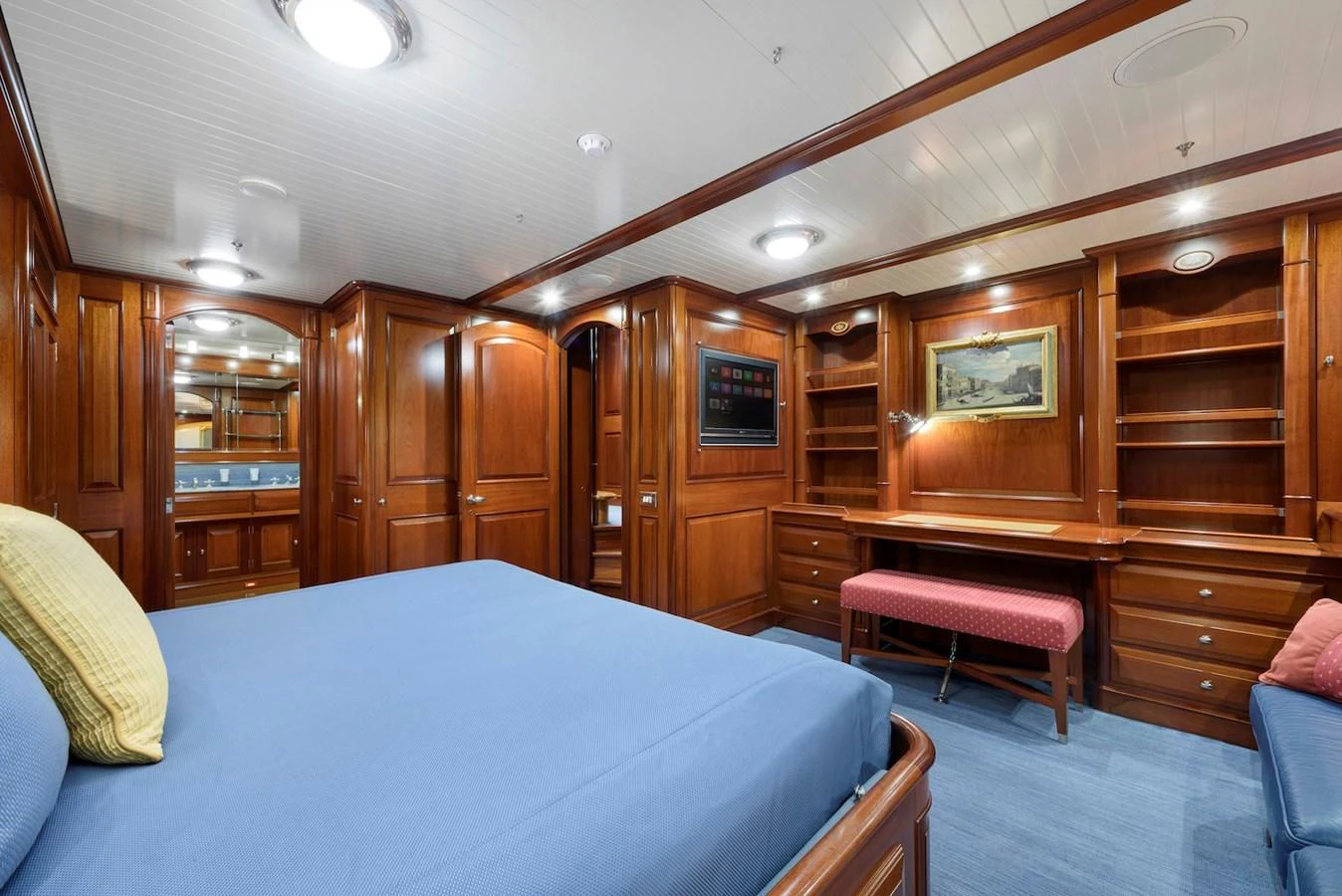 The stateroom features elegant wooden cabinetry, a comfortable bed, and a cozy seating area. aboard METEOR Yacht for Sale