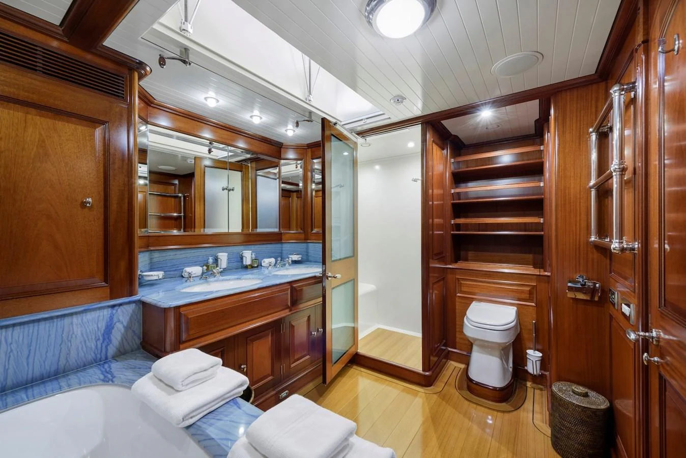The yacht's bathroom features elegant wood paneling, a spacious vanity, and modern fixtures. aboard METEOR Yacht for Sale