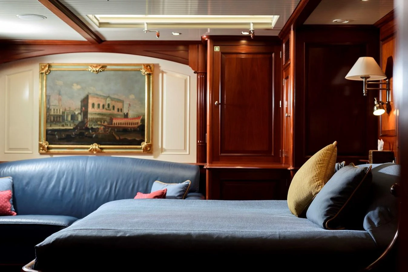 The stateroom features elegant wood paneling, a comfortable bed, and a classic painting, creating a warm and inviting atmosphere. aboard METEOR Yacht for Sale