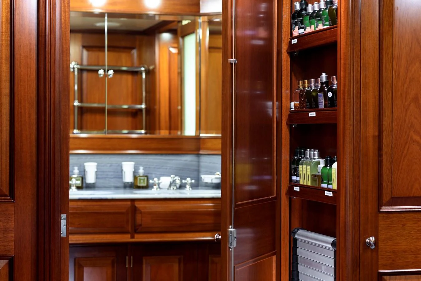 The yacht's bathroom features elegant wooden cabinetry and a well-organized storage area with luxury toiletries. aboard METEOR Yacht for Sale