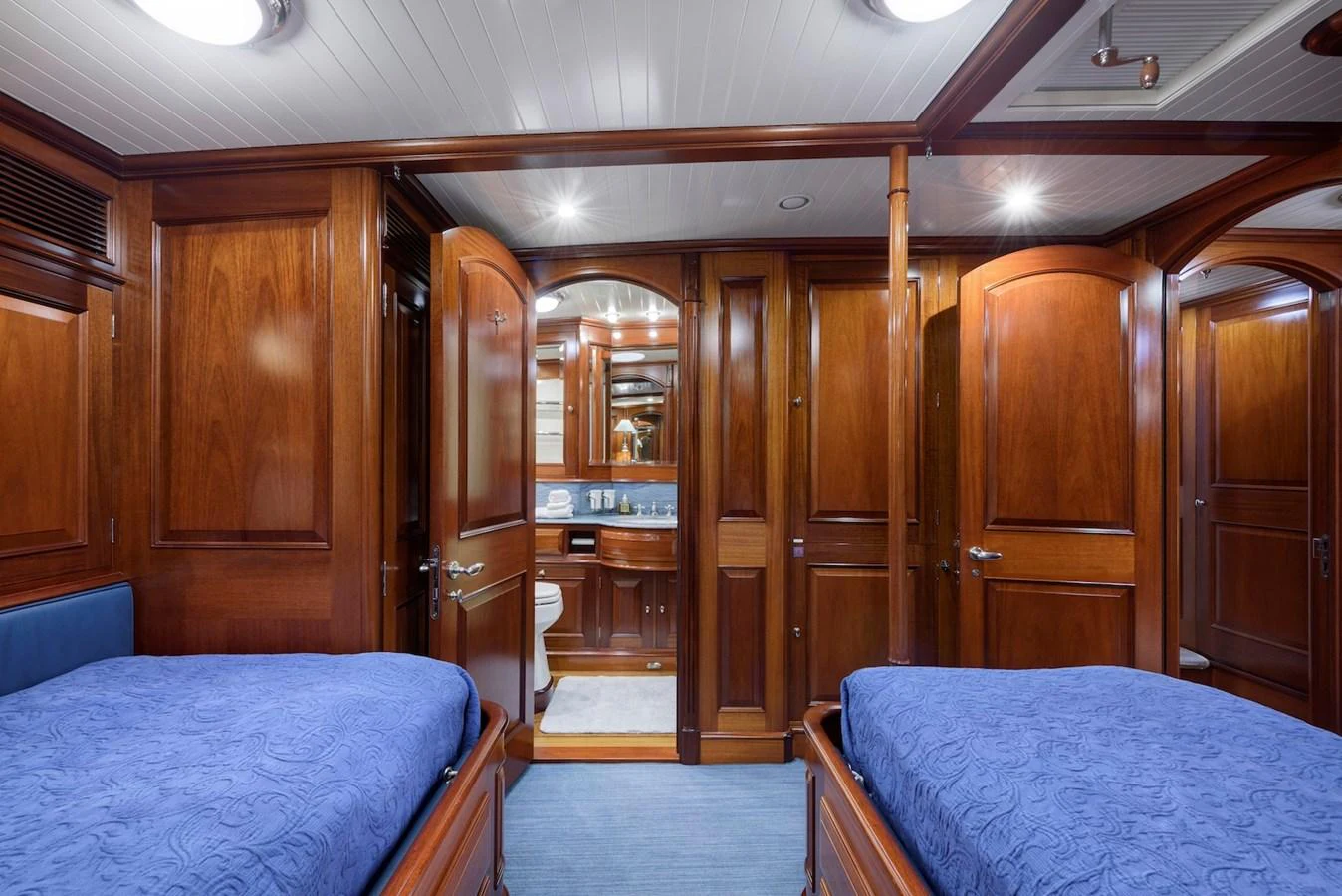 The guest stateroom features twin beds and rich wooden paneling, creating a warm and inviting atmosphere. aboard METEOR Yacht for Sale